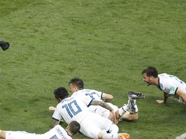 Para pemain Rusia menghampiri kiper, Igor Akinfeev (kiri) usai menahan tendangan penalti pemain Spanyol pada laga 16 besar Piala Dunia 2018 di  Luzhniki Stadium, Moskow, Rusia, (1/7/2018). Rusia menang penalti atas Spanyol Spain 4-3. (AP/David Vincent)