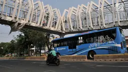 Bus Transjakarta melintas di bawah Skybridge Stasiun LRT Velodrome-Halte Transjakarta Pemuda, Jakarta, Selasa (11/6/2019). Pengoperasian LRT Kelapa Gading-Velodrome kembali diundur karena belum selesainya pembangunan Skybridge LRT Velodrome-Halte Transjakarta Pemuda. (merdeka.com/Iqbal Nugroho)