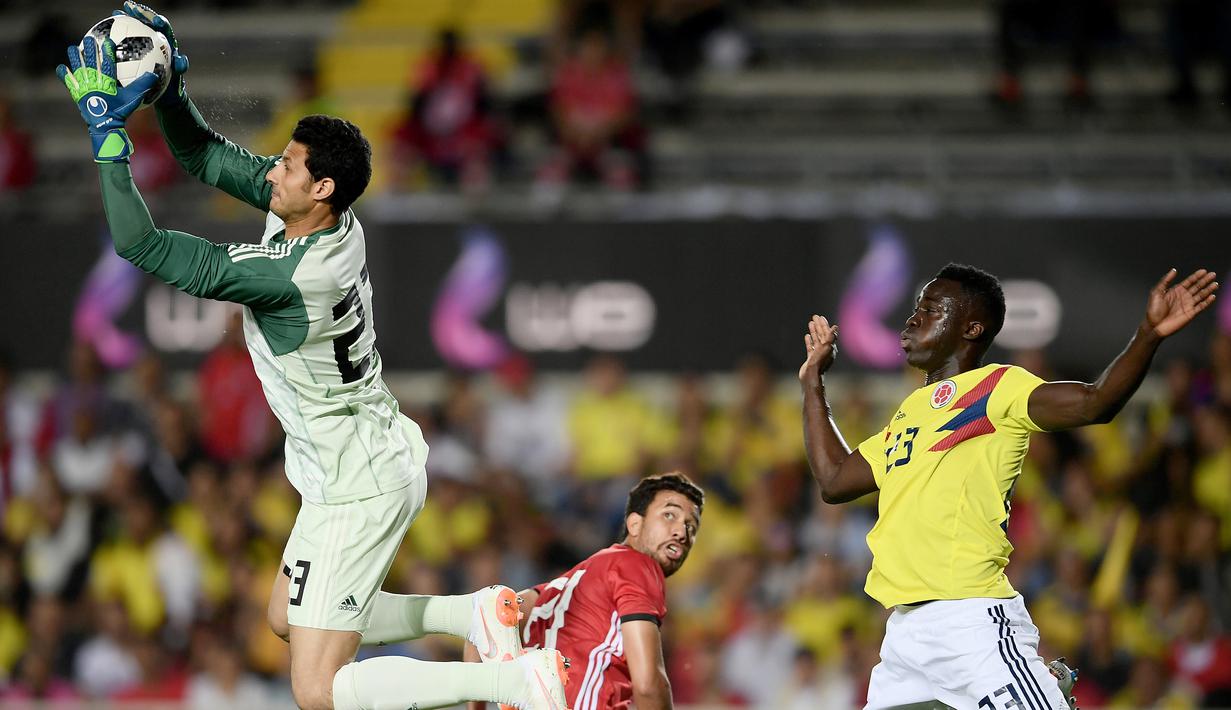 Aksi kiper Mesir, Mohamed El Shenawy (kiri) mengamankan bola dari jangkauan pemain Kolombia, Davinson Sanchez pada laga uji coba di "Atleti Azzurri d'Italia Stadium”, Bergamo, (1/6/2018). Mesir dan Kolombia bermain imbang 0-0. (AFP/Marco Bertorello)