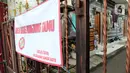 Spanduk pemberitahuan area batas kunjung tamu terpasang pada pagar di kawasan Intan Berduri, Sumur Batu, Jakarta, Rabu (9/06/2021). Kelurahan Sumur Batu memberlakukan mikro lockdown di RT 1, RT 2 dan RT di RW 03 setelah 34 warga positif COVID-19. (Liputan6.com/Herman Zakharia)