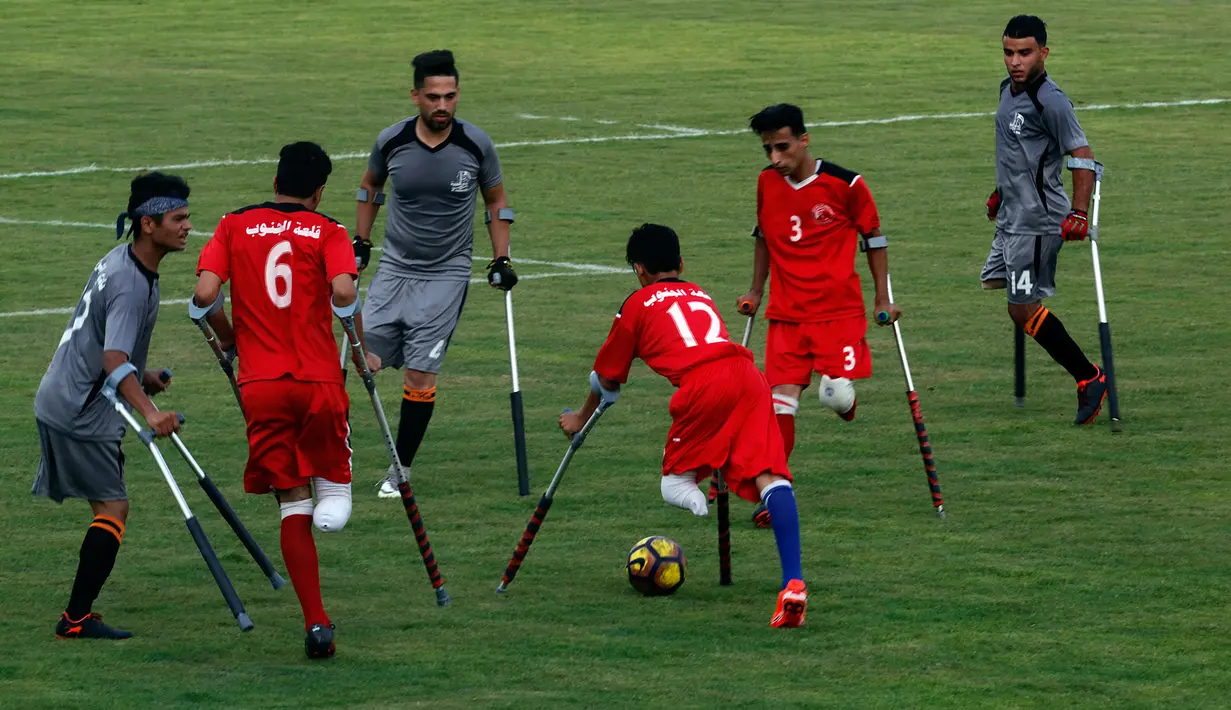 Warga Palestina yang diamputasi berusaha menggiring bola selama pertandingan  di stadion Kota Gaza, Selasa (27/8/2019). Turnamen lokal tersebut diadakan pertama kali bagi orang-orang Palestina yang kehilangan anggota tubuhnya akibat tembakan Israel di Jalur Gaza. (AP Photo/Hatem Moussa)