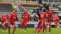 Bek Newcastle United, Ciaran Clark melepaskan sundulan sambil melompat ke gawang Liverpool dalam laga lanjutan Liga Inggris 2020/21 pekan ke-16 di St James' Park, Rabu (30/12/2020). Newcastle United bermain imbang 0-0 dengan Liverpool. (AFP/Stu Forster/Pool)