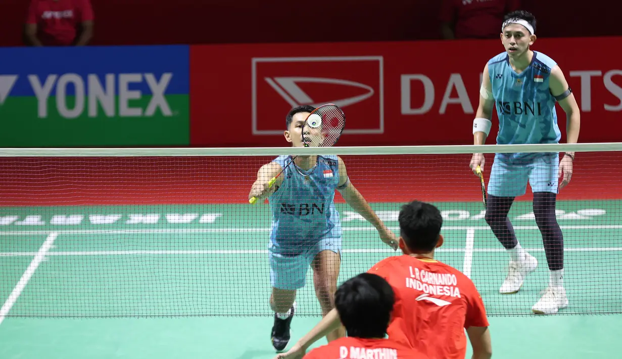 Pemain ganda putra Indonesia, Fajar Alfian (kiri) yang berpasangan dengan Muhammad Rian Ardianto berusaha mengembalikan serve saat menghadapi sesama pasangan Indonesia, Leo Rolly Carnando/Daniel Marthin pada laga semifinal Daihatsu Indonesia Masters 2024 di di Istora Senayan, Jakarta, Sabtu (27/1/2024). Fajar/Rian kalah rubber game dengan skor 21-19, 14-21 dan 17-21. (Bola.com/Pradipta Rama)