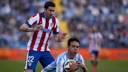 Gelandang Atletico, Ruben Garcia menjatuhkan bek Malaga, Weligton