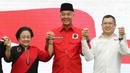 Ketua Umum PDIP Megawati Soekarnoputri (kiri) bersama Ketua Umum Partai Perindo Hary Tanoesoedibjo (kanan) dan Bakal calon presiden Ganjar Pranowo mengangkat tangan usai penandatanganan kerja sama politik di Kantor DPP PDIP, Jakarta, Jumat (9/6/2023). (Liputan6.com/Herman Zakharia)
