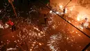 Sejumlah pemuda Palestina mengayunkan kembang api buatan sendiri, saat orang-orang merayakannya pada malam menjelang bulan suci Ramadan, di kamp Rafah untuk pengungsi Palestina di Jalur Gaza selatan (11/4/2021). (AFP Photo/Mohammed Abed)