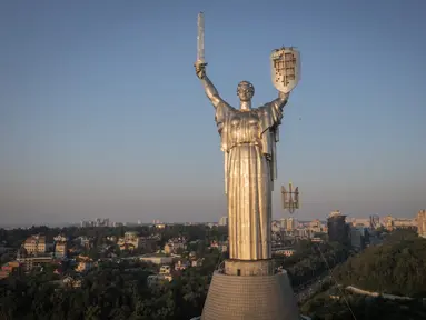 Para pekerja memasang lambang Ukraina pada perisai di tangan monumen tertinggi di negara itu, Monumen Tanah Air, setelah lambang Soviet dihapus, di Kiev, Ukraina, Minggu, 6 Agustus 2023. (AP Photo/Efrem Lukatsky)