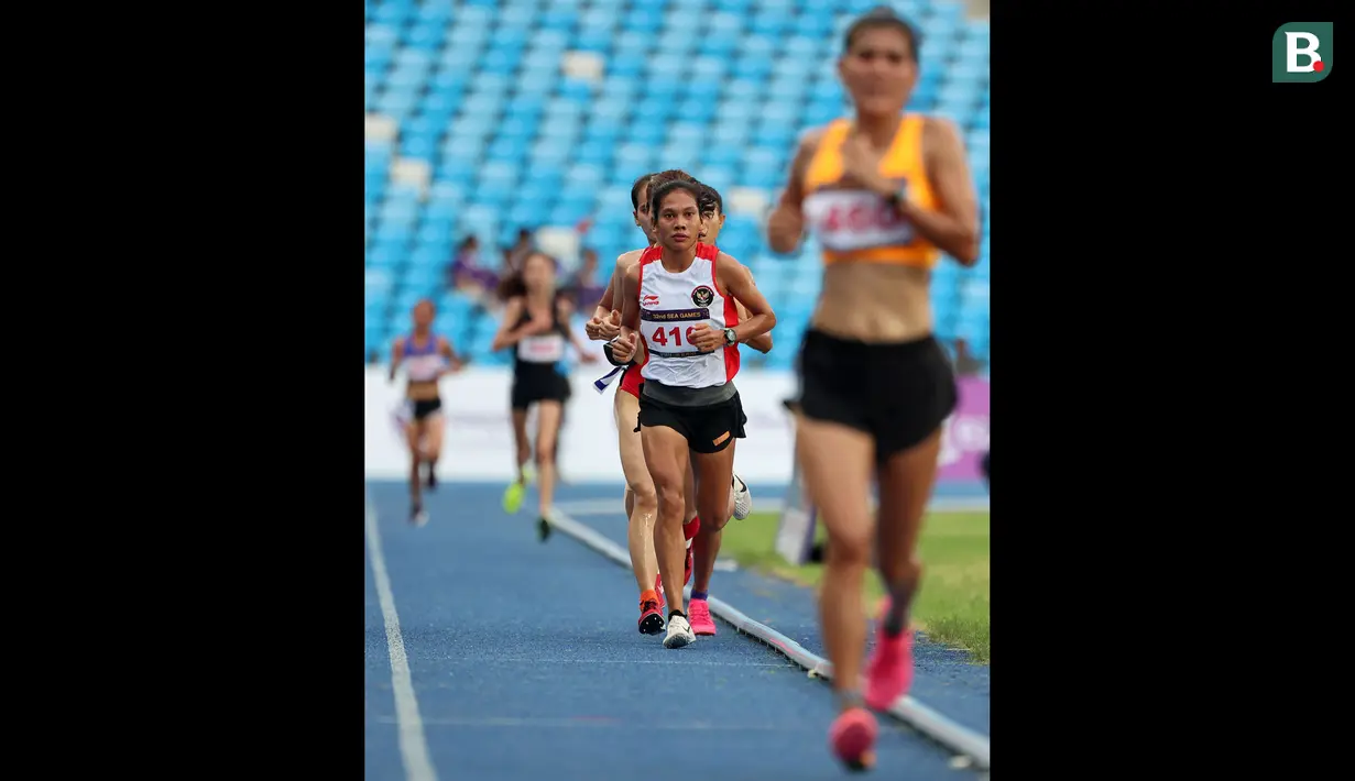 Reaksi pelari putri Indonesia, Odekta Elvina Naibaho (tengah) berkompetisi pada nomor lari 10.000 meter SEA Games 2023 di Stadion Morodok Techo National Stadium, Phnom Penh, Kamboja, Jumat (12/5/2023). Odekta meraih medali perunggu dengan catatan waktu 35 menit 31,03 detik sementara medali emas dan perak direbut dua atlet Vietnam, Thi Oanh Nguyen (35 menit 11,53 detik) dan Thi Hong Le Pham (35 menit 21,09 detik). (Bola.com/Abdul Aziz)