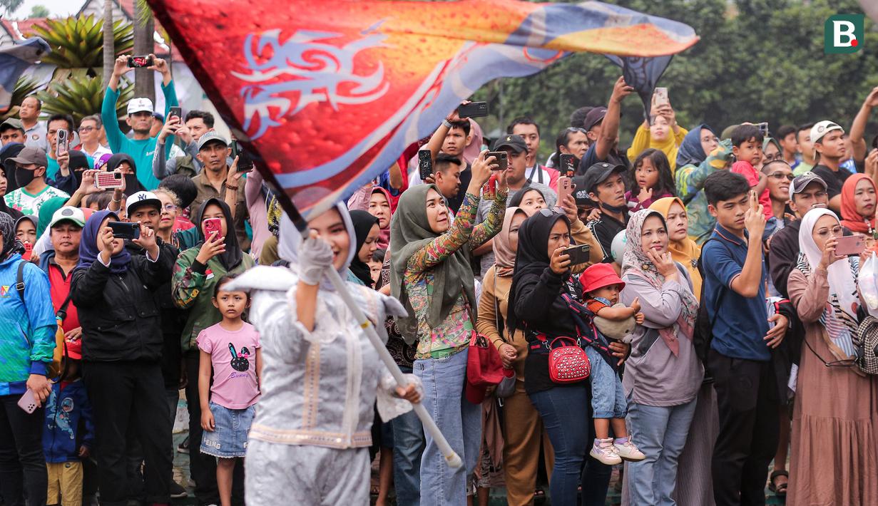 Para warga masyarakat Kabupaten Bandung menyaksikan penampilan grup drum band lokal dalam rangkaian acara Trophy Experience menyambut Piala Dunia U-17 2023 di Plaza Upakarti, Soreang, Kabupaten Bandung, Minggu (22/10/2023) sore WIB. (Bola.com/Bagaskara Lazuardi)