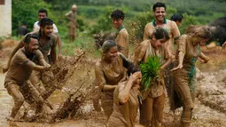 Para pemuda bermain lumpur sawah saat merayakan Asar Pandra atau hari menanam padi di Distrik Dhading, Nepal, Minggu (30/6/2019). Umat Hindu Nepal menganggap Asar Pandra sebagai hari baik untuk menanam padi. (AP Photo/Niranjan Shrestha)