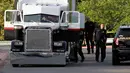 Polisi San Antonio selidiki truk yang berisi sembilan mayat di lapangan parkir sebuah supermarket, Texas, Minggu (23/7).  Selain menemukan korban tewas, 30 orang lainnya juga diselamatkan di dalam truk itu, 17 dalam kondisi kritis. (AP Photo/Eric Gay)