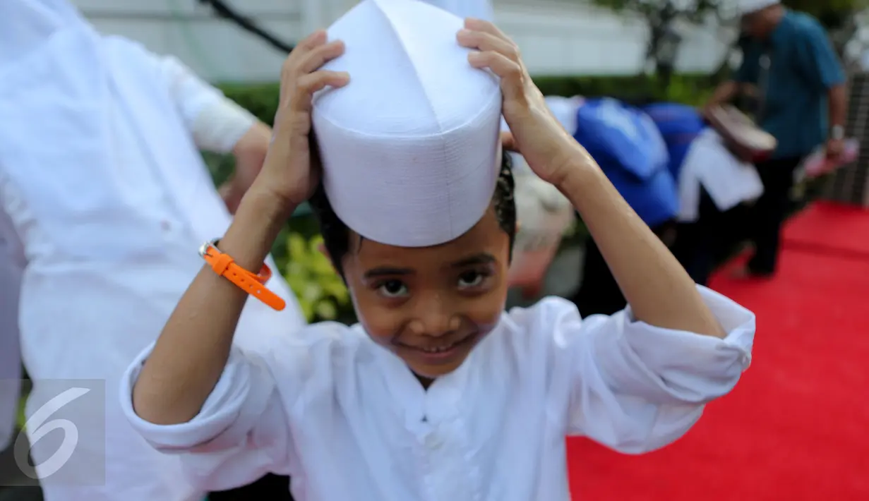 Seorang anak yatim terlihat tersenyum usai mengambil air wudhu, Jakarta, Kamis (18/6/2015). Jokowi mengundang 400 anak yatim dari 12 panti asuhan yang ada di Jabodetabek untuk berbuka puasa bersama di Isatana Negara (Liputan6.com/Faizal Fanani)