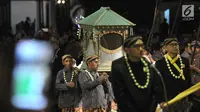 Abdi keraton membawa pusaka saat mengikuti upacara ritual Kirab Pusaka dan Tapa Bisu di Solo, Sabtu (31/8/2019) malam. Kirab tersebut dalam rangka memperingati pergantian tahun baru Hijriah yand dalam penanggalan Jawa disebut satu Suro. (merdeka.com/Iqbal S Nugroho)
