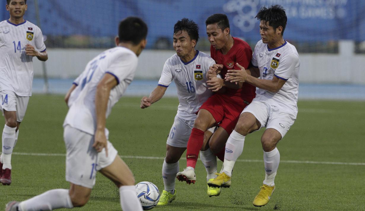 Gelandang Timnas Indonesia U-22, Evan Dimas, terjepit saat melawan Laos U-22 pada laga SEA Games 2019 di Stadion City of Imus Grandstand, Manila, Kamis (5/12). Indonesia menang 4-0 atas Laos. (Bola.com/M Iqbal Ichsan)