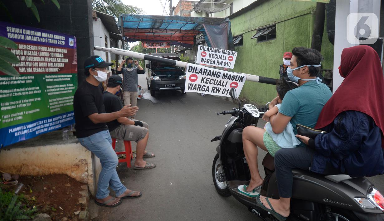 Sejumlah pemuda menjaga portal karantina wilayah menuju RW 10 di kawasan Tanah Kusir, Kelurahan Kebayoran Lama Selatan, Jakarta, Rabu (8/4/2020). Warga menerapkan akses satu pintu masuk pemukiman yang terdiri dari 12 RT tersebut untuk mencegah penyebaran corona COVID-19. (merdeka.com/Dwi Narwoko)