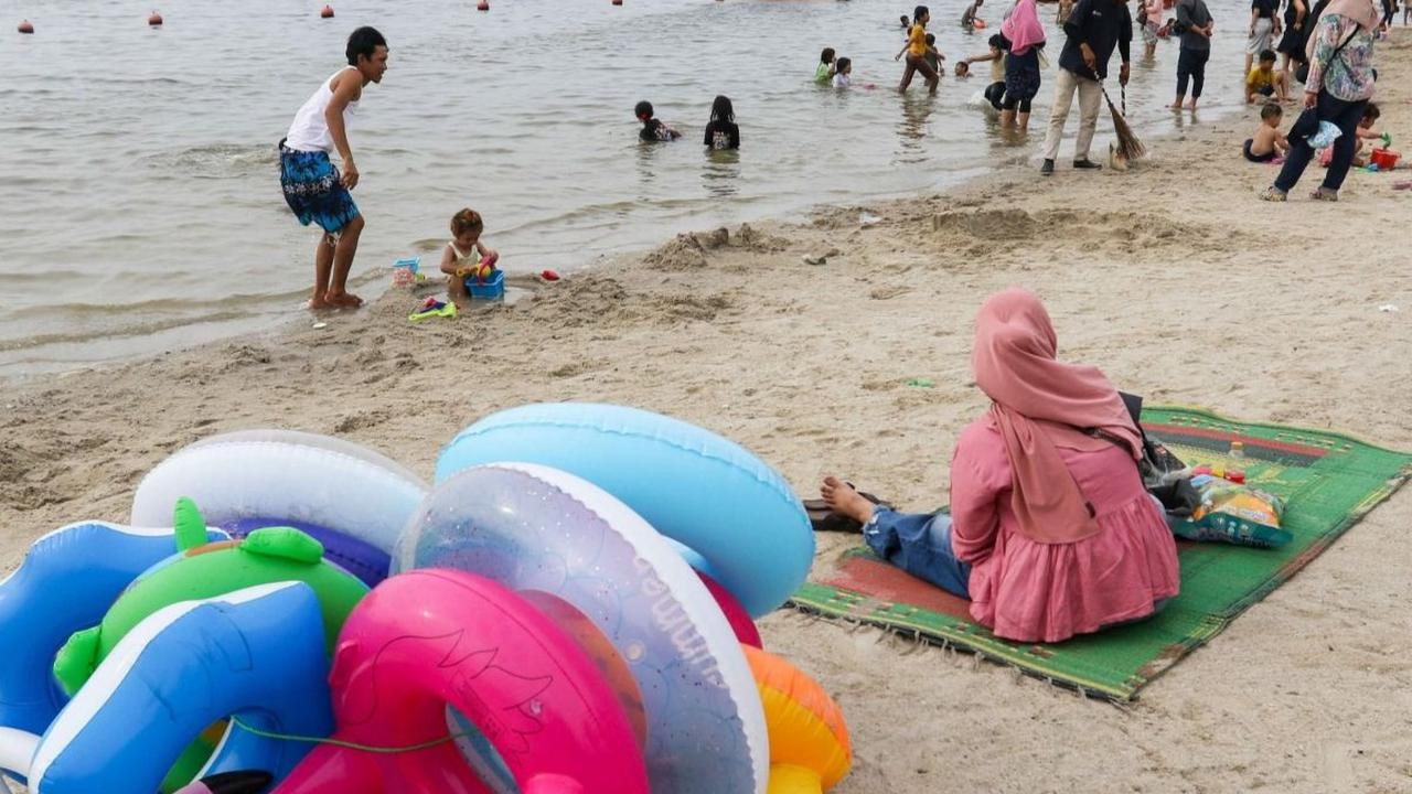 Berdasarkan data yang dirilis oleh PT Pembangunan Jaya Ancol Tbk, hingga pukul 16:00 WIB, sebanyak 22.000 pengunjung telah memadati kawasan wisata populer tersebut. Foto: Liputan6.com / Herman Zakharia<br>