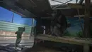 Simpanse terlihat saat petugas membawa makanan melewati kandangnya di Attica Zoological Park, di Spata, dekat Athena, pada 21 Januari 2021. Setelah hampir tiga bulan tutup karena COVID-19, satu-satunya kebun binatang Yunani terancam tutup akibat tidak ada pemasukan. (AP Photo/Petros Giannakouris)