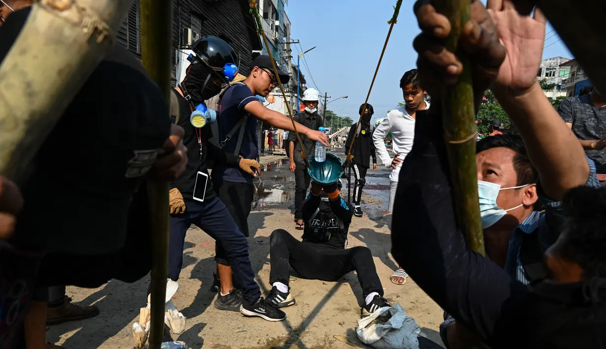 Para pengunjuk rasa menguji senjata ketapel besar ketika pasukan keamanan melanjutkan tindakan keras terhadap demonstrasi menentang kudeta militer di Yangon, Rabu (17/3/2021). (AFP/STR)