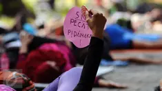 Salah satu perempuan pegiat antikorupsi menunjukkan tulisan saat melakukan yoga dan aksi penyampaian pendapat di Taman Suropati, Jakarta, Minggu (6/12). Kegiatan ini juga bentuk peringatan Hari Anti korupsi. (Liputan6.com/Helmi Fithriansyah)