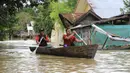Warga mendayung perahu kayu saat banjir di Lhoksukon, Aceh Utara, Aceh, 3 Januari 2022. Berdasarkan data Badan Penanggulangan Bencana Daerah (BPBD) Aceh Utara, banjir mengakibatkan 2.278 jiwa terdampak dan satu orang anak meninggal dunia. (AZWAR IPANK/AFP)