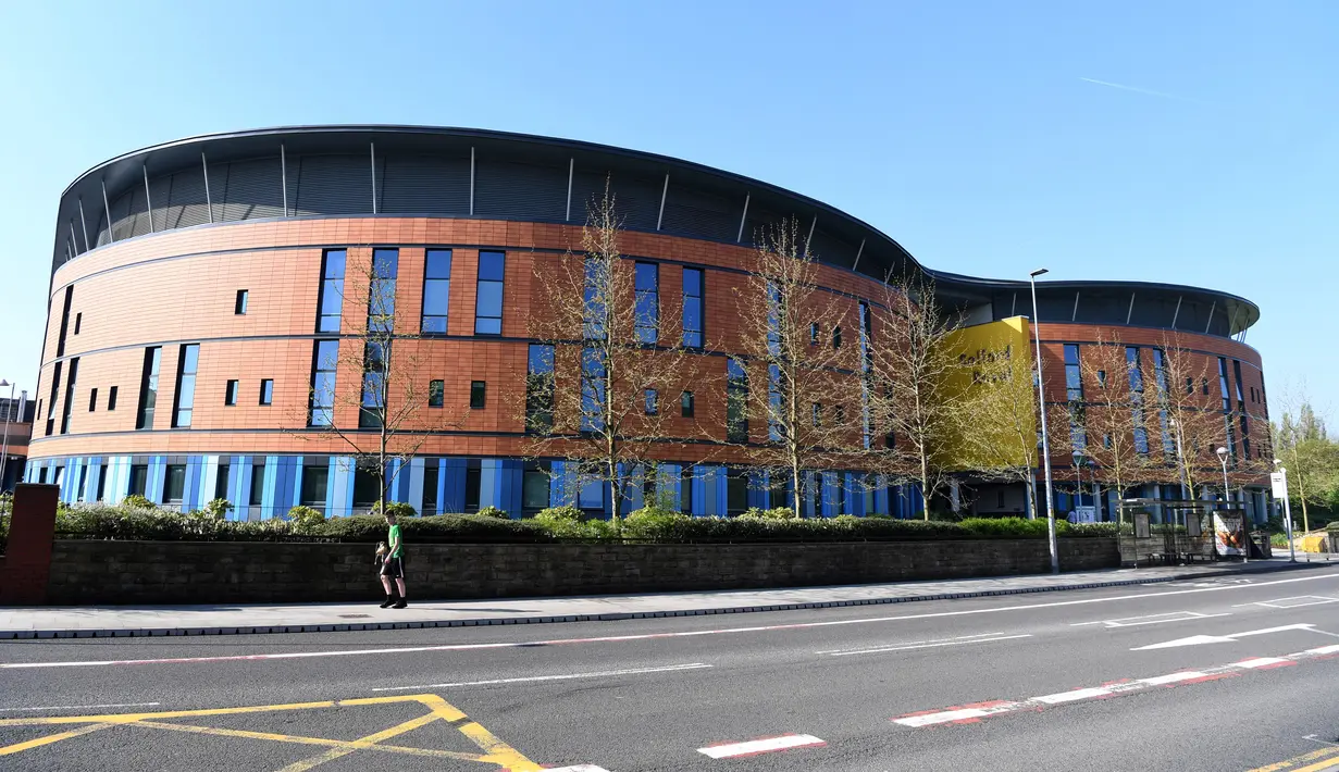 Warga melintas di dekat Rumah Sakit Salford Royal di Salford, Greater Manchester, Inggris (6/5). Operasi Sir Alex Ferguson berjalan sangat lancar, tapi ia membutuhkan perawatan intensif untuk memulihkan tubuhnya. (AFP Photo/Paul Ellis)