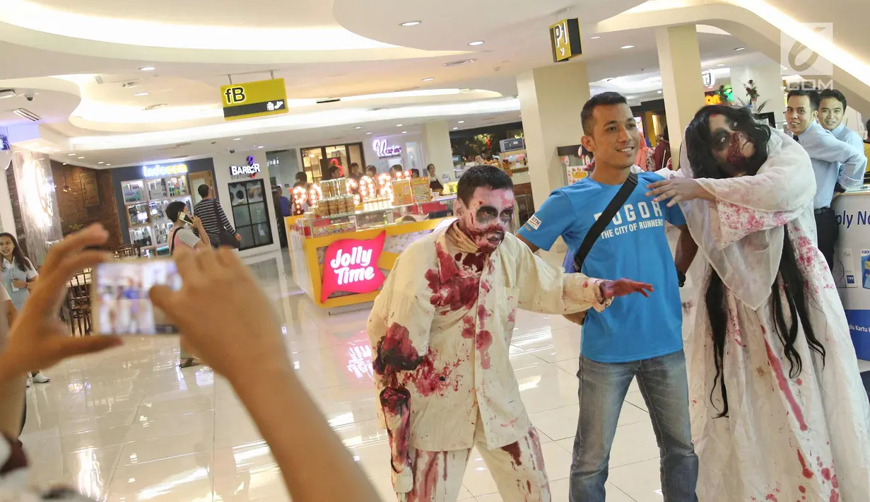 Pengunjung foto dengan zombie dan kuntilanak di pusat perbelanjaan kawasan Sudirman, Jakarta, (31/10). Pusat perbelanjaan di kawasan Sudirman menghadirkan 3 cosplay, Zombie, Kuntilanak dan valak merayakan Halloween. (Liputan6.com/Herman Zakharia)