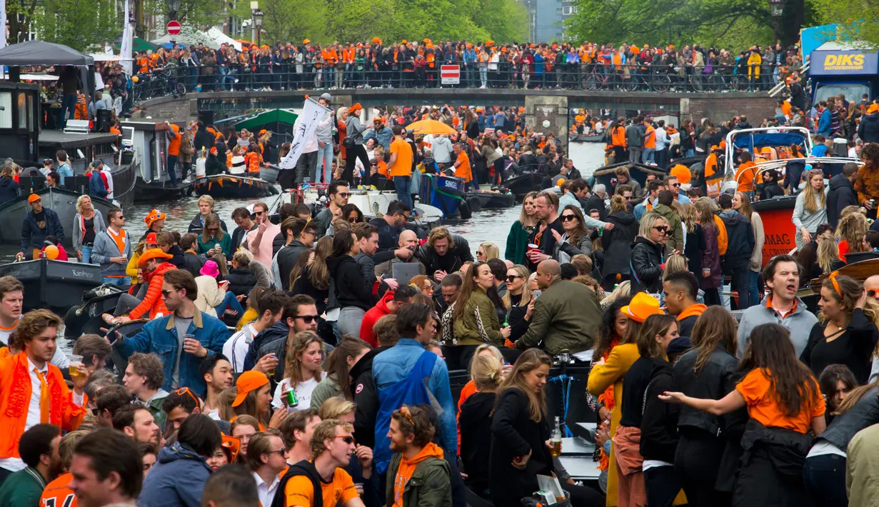Warna nasional Belanda, oranye, mendominasi jalan dan kanal pada Hari Ulang Tahun Raja atau King's Day di Amsterdam, 27 April 2018. Pada Hari Raja, masyarakat diperbolehkan menjual berbagai barang di jalan tanpa memerlukan izin. (AP/Peter Dejong)