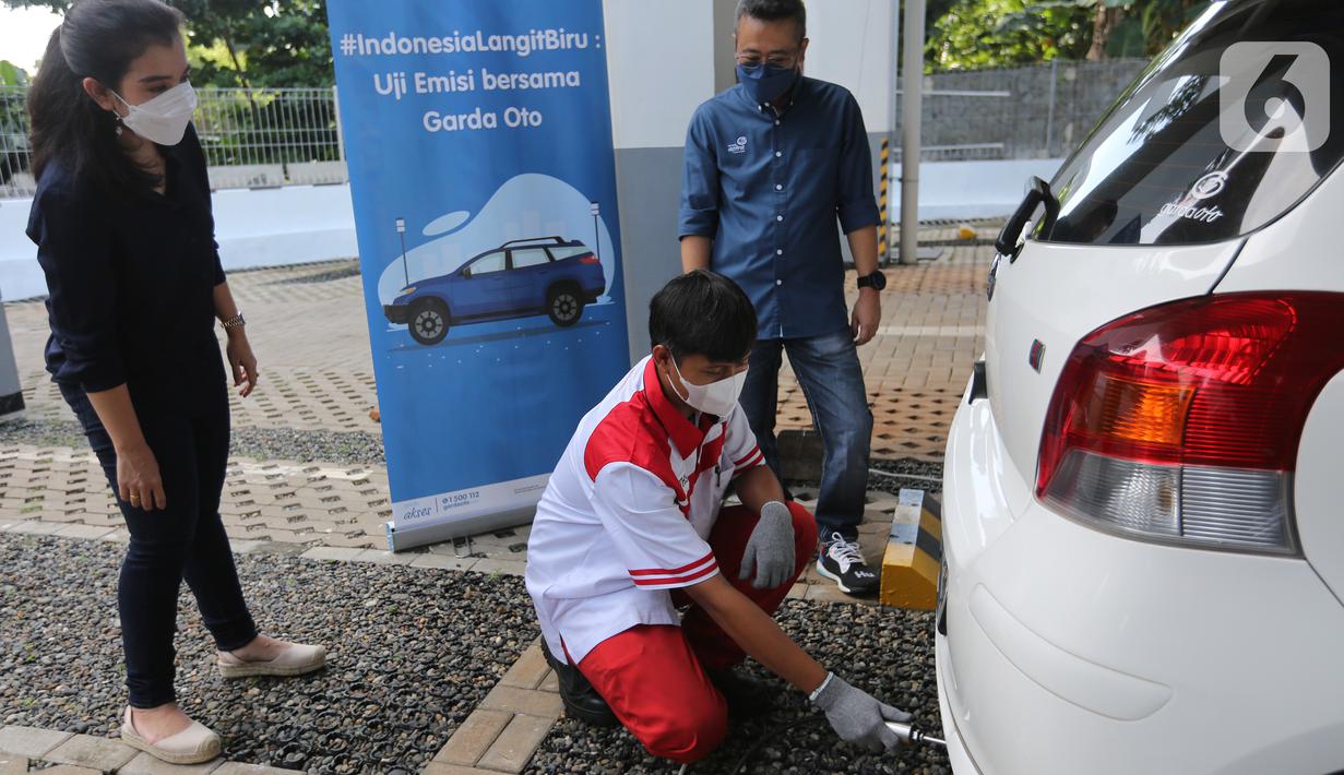 COO Asuransi Astra Hendry Yoga (kanan) berbincang dengan pelanggan Garda Oto saat uji emisi gratis Asuransi Astra, di Jakarta, Minggu (12/12/2021). Sebanyak 400 mobil berusia diatas 3 tahun dari berbagai merk ikuti uji emisi dalam kampanye #IndonesiaLangitBiru. (Liputan6.com/Fery Pradolo)