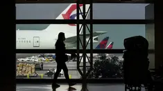 Siluet pelancong dengan masker di samping kopernya di Bandara Internasional Los Angeles di Los Angeles, California, 23 November 2020. Sekitar 1 juta orang Amerika memadati bandara dan pesawat menjelang libur Thanksgiving pekan ini bahkan saat kematian akibat COVID-19 melonjak. (AP Photo/Jae C. Hong)