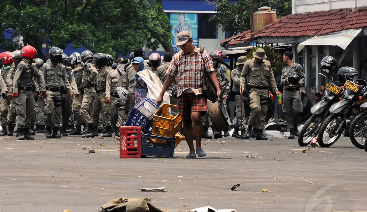 Seorang pria menyeret barang bekas usai pembongkaran kios di Terminal Depok, Jawa Barat, (8/10/2014). (Liputan6.com/Helmi Fithriansyah)