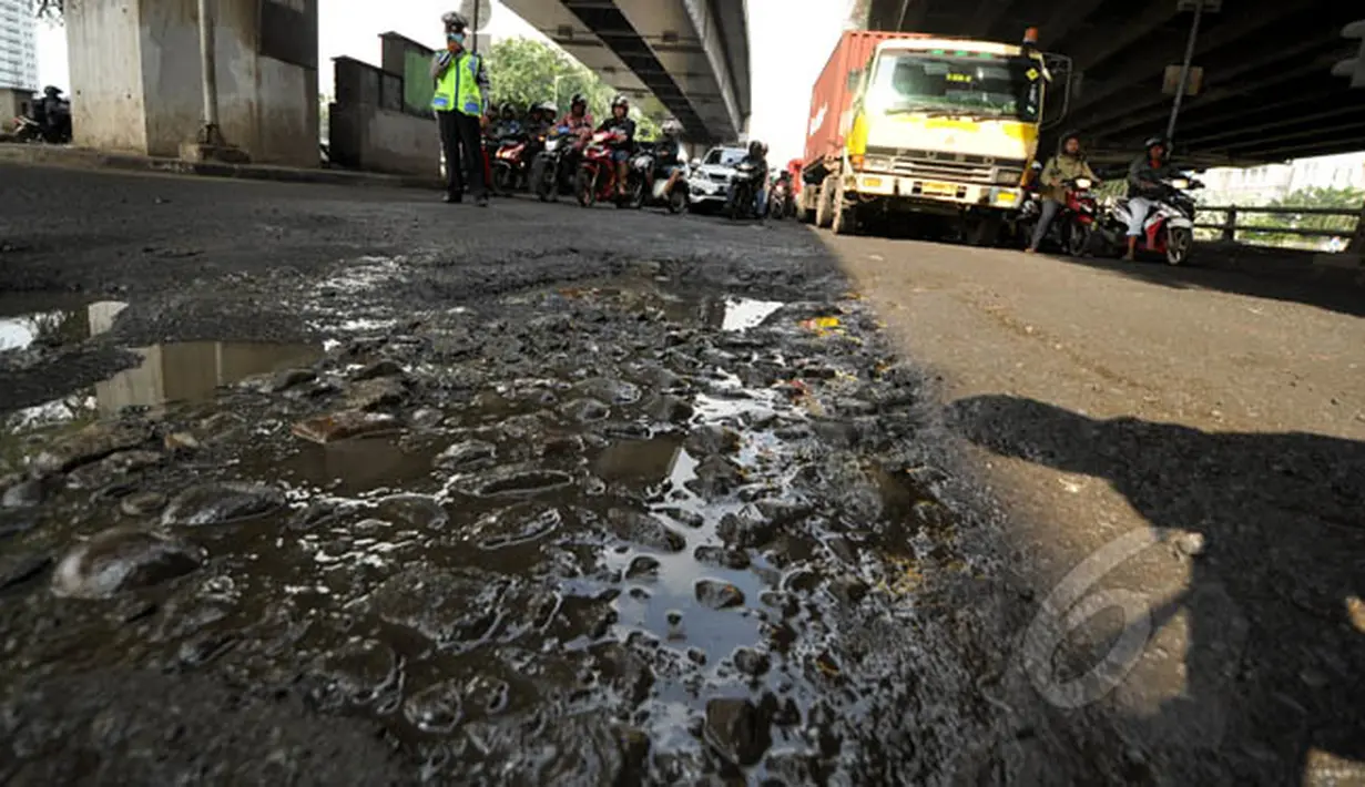 Jalan rusak dan berlubang di Jalan R.E Martadinata, Jakarta, Senin (16/2/2015). Hujan deras serta ruas jalan yang terendam air mengakibatkan badan jalan menjadi rusak dan berlubang. (Liputan6.com/Faizal Fanani)