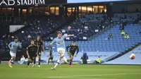 Gelandang Manchester City, Kevin de Bruyne, saat mengeksekusi penalti ke gawang Arsenal dalam laga Liga Inggris di Etihad Stadium, 17 Juni 2020. (Peter Powell/Pool via AP)