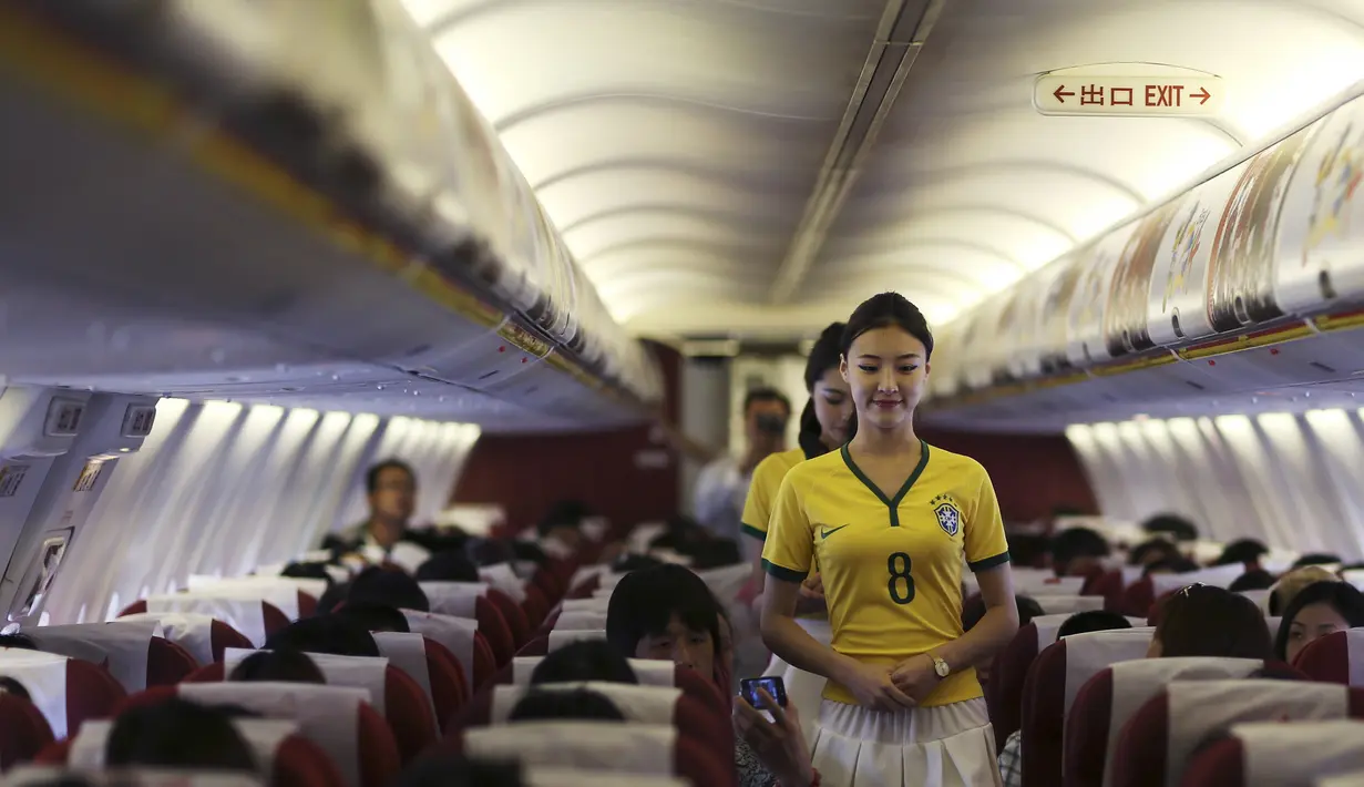 Penampilan pramugari tersebut terlihat semakin menarik dan cantik dengan panduan kaos bola dan rok pendek, China, Senin (23/6/14). (REUTERS/Wong Campion)