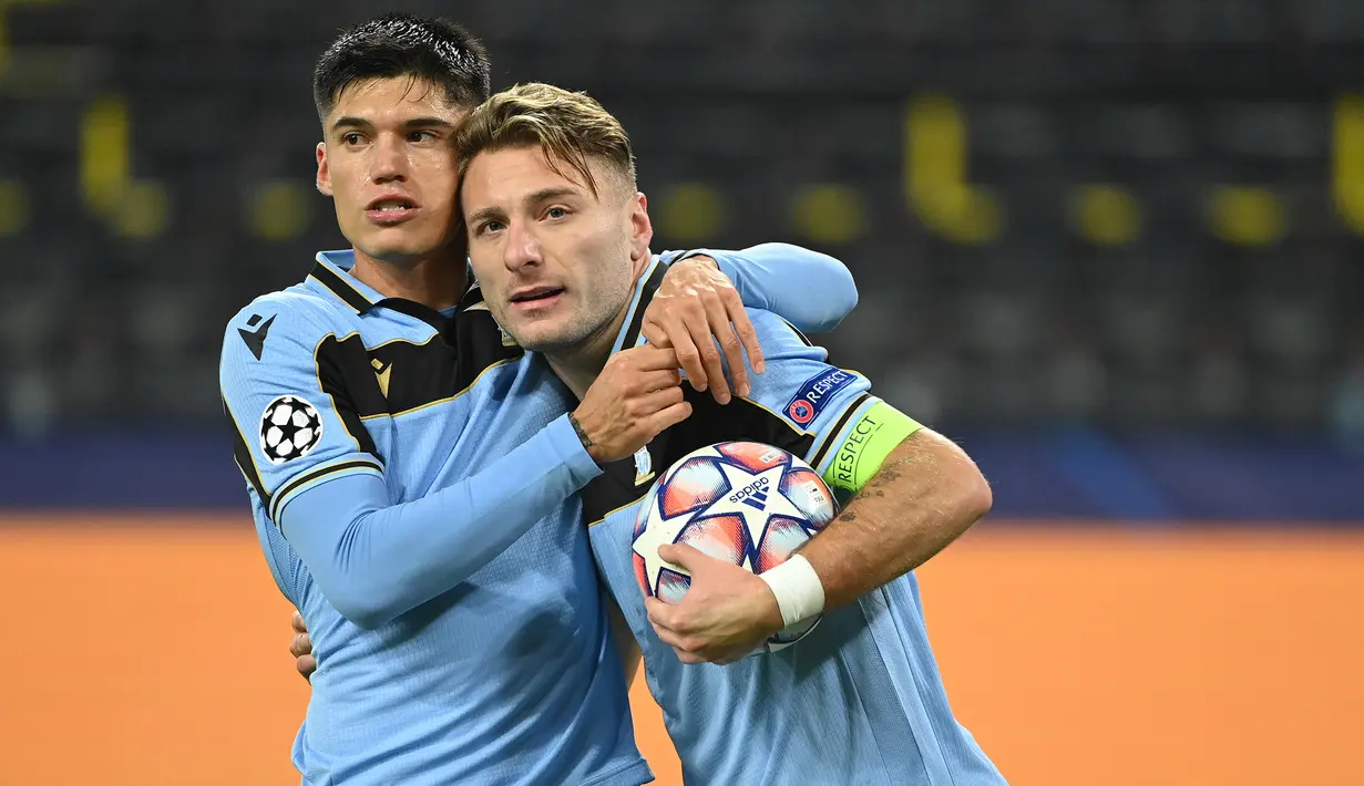 Striker Lazio, Ciro Immobile (kanan), melakukan selebrasi usai mencetak gol ke gawang Borussia Dortmund dalam laga lanjutan Liga Champions 2020/21 Grup F di Signal Iduna Park Stadium, Dortmund, Rabu (2/12/2020) waktu setempat. Lazio bermain imbang 1-1 dengan Dortmund. (AFP/Ina Fassbender)