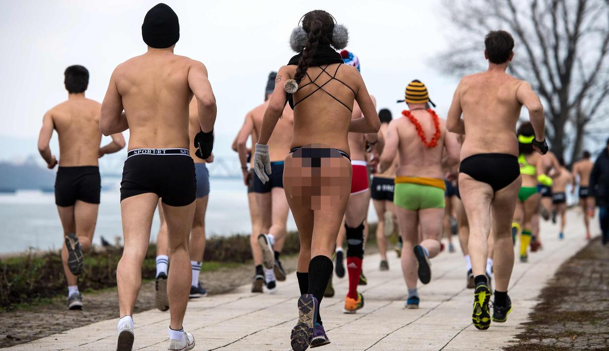 Peserta berlari saat mengikuti lomba Underpants Run di tepi sungai Danube di Beograd, Serbia (4/2). Dengan hanya mengenakan pakaian dalam para peserta tetap semangat mengikuti lomba dengan suhu mendekati nol derajat Celcius. (AFP Photo/Andrej Isakovic)