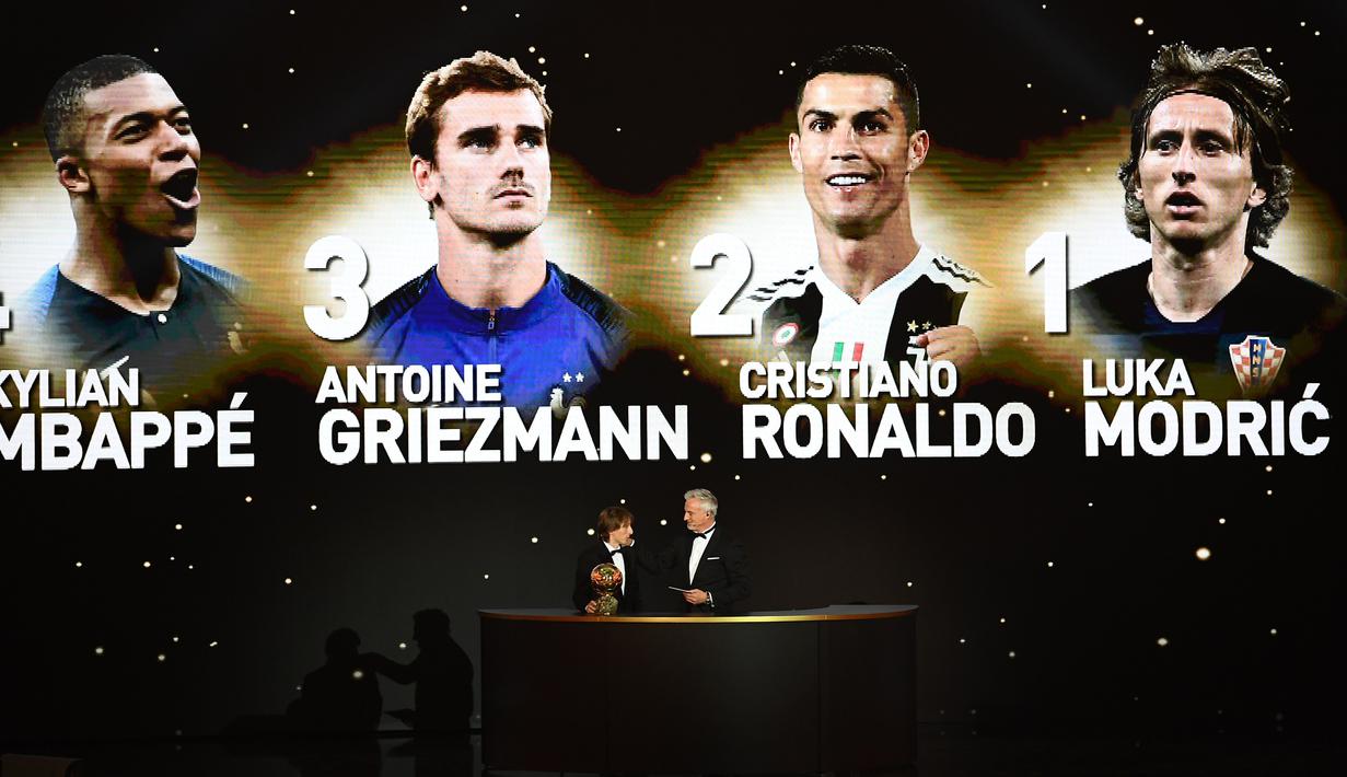 Gelandang Real Madrid asal Kroasia, Luka Modric, bersama legenda David Ginola saat malam penghargaan Ballon d'Or di Paris, Senin (3/12). Dirinya berhasil meraih gelar Ballon d'Or. (AFP/Franck Fife)