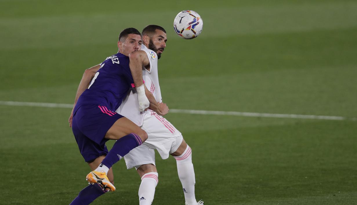 Penyerang Real Madrid, Karim Benzema, berebut bola dengan bek Real Valladolid, Javi Sanchez, pada laga lanjutan Liga Spanyol di Estadio Alfredo Di Stefano, Kamis (1/10/2020) dini hari WIB. Real Madrid menang 1-0 atas Valladolid. (AP Photo/Manu Fernandez)