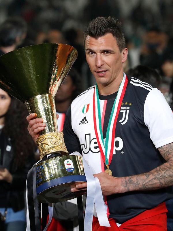 Striker Juventus, Mario Mandzukic berpose dengan Piala Liga Italia Serie A di Stadion Allianz, Turin (19/5/2019). Juventus berhasil meraih 97 angka dengan unggul 11 angka dari Napoli yang berada di peringkat kedua. (AP Photo/Antonio Calanni)