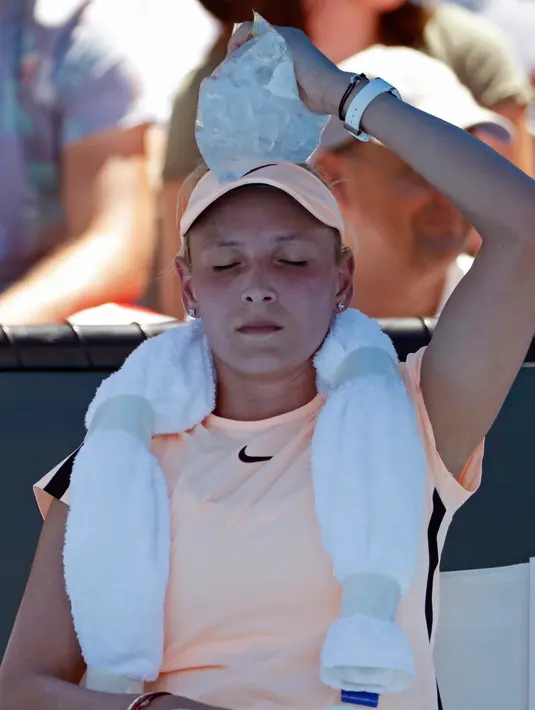 Petenis Kroasia Donna Vekic mendinginkan kepalanya dengan es saat istirahat selama bertanding melawan Nao Hibino dari Jepang dalam pertandingan putaran pertama Australia Terbuka 2018 di Melbourne, Australia, (16/1). (AP Photo / Ng Han Guan)