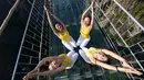 Para perempuan melakukan gerakan yoga di jembatan kaca di Taman Nasional Shiniuzhai di Pingjiang, provinsi Hunan, China, Kamis (5/11). Latihan yang dilakukan seratus wanita itu untuk mempromosikan hidup sehat dengan beryoga. (REUTERS/China Daily)