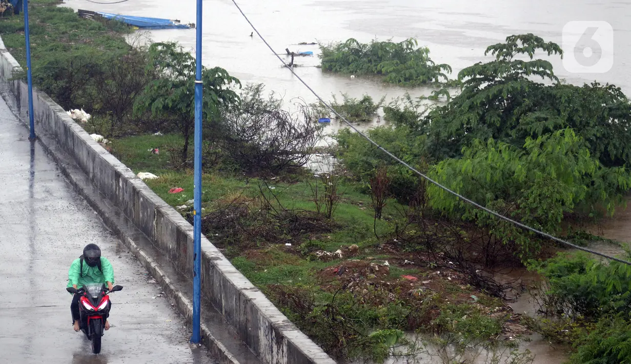 Pengendara melintas di jalan inspeksi Banjir Kanal Barat di Kawasan Tanah Abang, Jakarta, Rabu (1/1/2020). Hujan yang mengguyur Jakarta sejak Selasa sore (31/12/2019) mengakibatkan debit air Banjir Kanal Barat tinggi dan hampir meluap. (Liputan6.com/Helmi Fithriansyah)