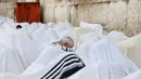 Seorang umat Yahudi terlihat khusuk berdoa di tembok ratapan di Kota Tua Yerusalem selama hari libur Sukkot, (19/10). Perayaan ini dirayakan selama tujuh hari pada bulan purnama di antara bulan September dan Oktober. (REUTERS/Baz Ratner)