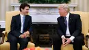 Presiden AS, Donald Trump dan PM Kanada, Justin Trudeau berbincang di Oval Office, Gedung Putih, Washington, Senin (13/2). Kedatangannya PM Kanada ke Gedung Putih untuk membahas isu memajukan perempuan di dunia bisnis. (AP Photo/Evan Vucci)
