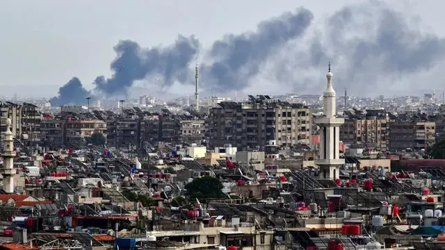 Asap mengepul di atas gedung-gedung setelah serangan Israel di pinggiran Damaskus, Suriah, pada 22 November 2023. (AFP)