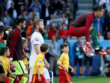 Pemain Portugal, Cristiano Ronaldo, meregangkan otot dengan melompat jelang melawan Islandia pada laga Grup F Piala Eropa 2016 di Stade Geoffroy Guichard, Saint-Etienne, Rabu (15/6/2016) dini hari WIB. (Reuters/Robert Pratta)