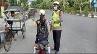 Seorang Polwan menghentikan pelajar yang memakai sepeda listrik di jalan raya, 18/7/2022 (korlantas.polri.go.id)