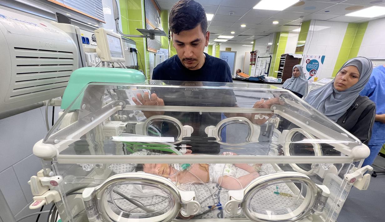 Ayman Abou Chamalah, seorang warga Palestina berusia 34 tahun, dan keluarganya melarikan diri dari pemboman Israel di Kota Gaza untuk berlindung dengan kerabatnya di Rafah, di selatan wilayah yang dikuasai Hamas. (Mai YAGHI / AFP)