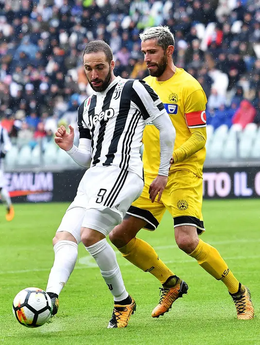 Striker Juventus, Gonzalo Higuain, berusaha melewati gelandang Udinese, Valon Behrami, pada laga Serie A di Stadion Allianz, Minggu (11/3/2018). Juventus menang 2-0 atas Udinese. (AP/Alessandro di Marco)