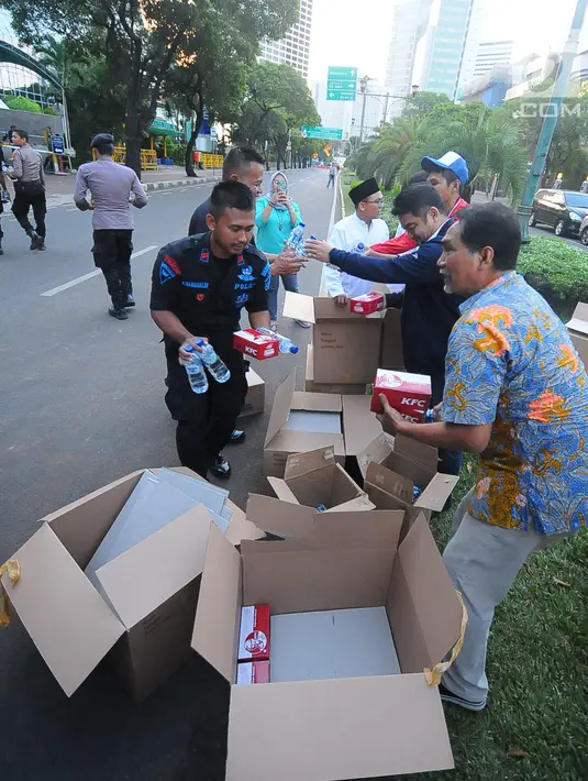 Koordinator Nasional Relawan GOJO (Golkar Jokowi) Rizal Malarangeng (batik) memberikan makanan berbuka kepada para aparat yang melakukan penjagaan gedung KPU, Menteng, Jakarta Pusat, Kamis (23/5/). (Liputan6.com/Angga Yuniar)