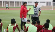 Pelatih kepala Timnas Indonesia U-19, Indra Sjafri (kiri) didampingi asisten pelatih, Bima Sakti memberi pengarahan kepada para pemainnya dalam rangkaian pemusatan latihan Timnas Indonesia U-19 di Stadion Madya, Senayan, Jakarta, Senin (1/7/2024) sebagai persiapan menghadapi ajang Piala AFF U-19 2024 yang akan berlangsung pada 17 hingga 29 Juli 2024. (Bola.com/M Iqbal Ichsan)